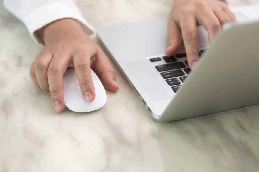 Closeup of business woman hand typing on laptop keyboard