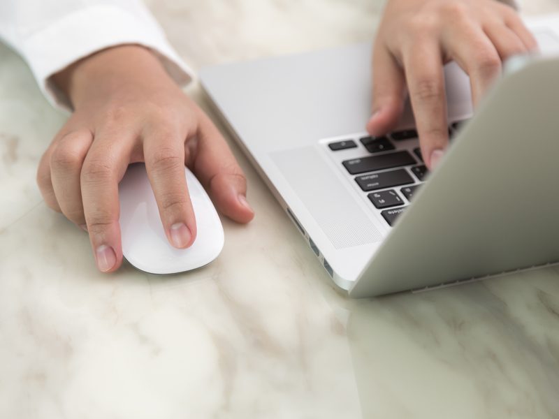 Closeup of business woman hand typing on laptop keyboard